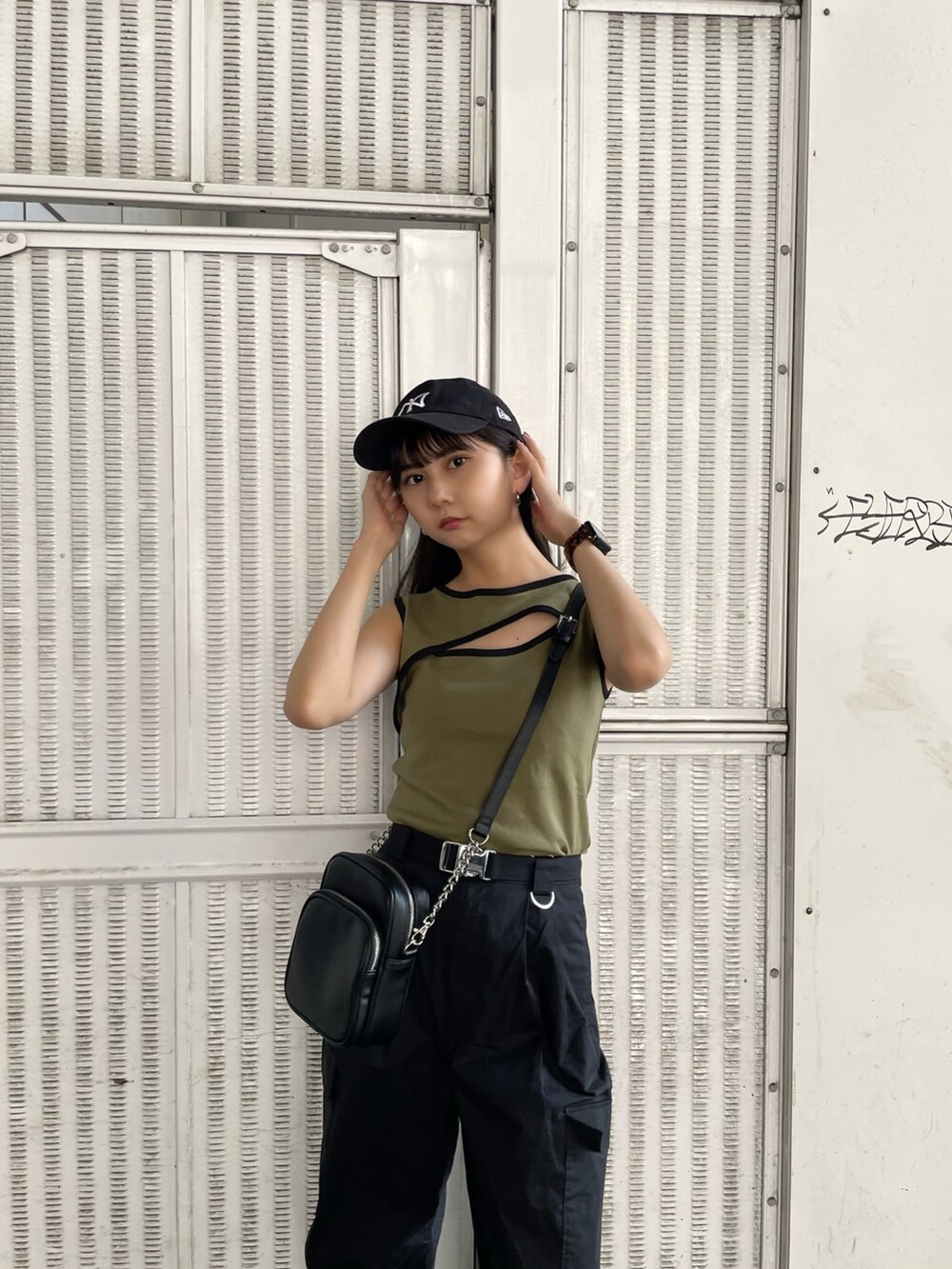 ベージュ系のタンクトップ、ブラック系のカーゴパンツ、ブラック系のサンダルを着用したレディースの夏コーディネートの5枚目の写真