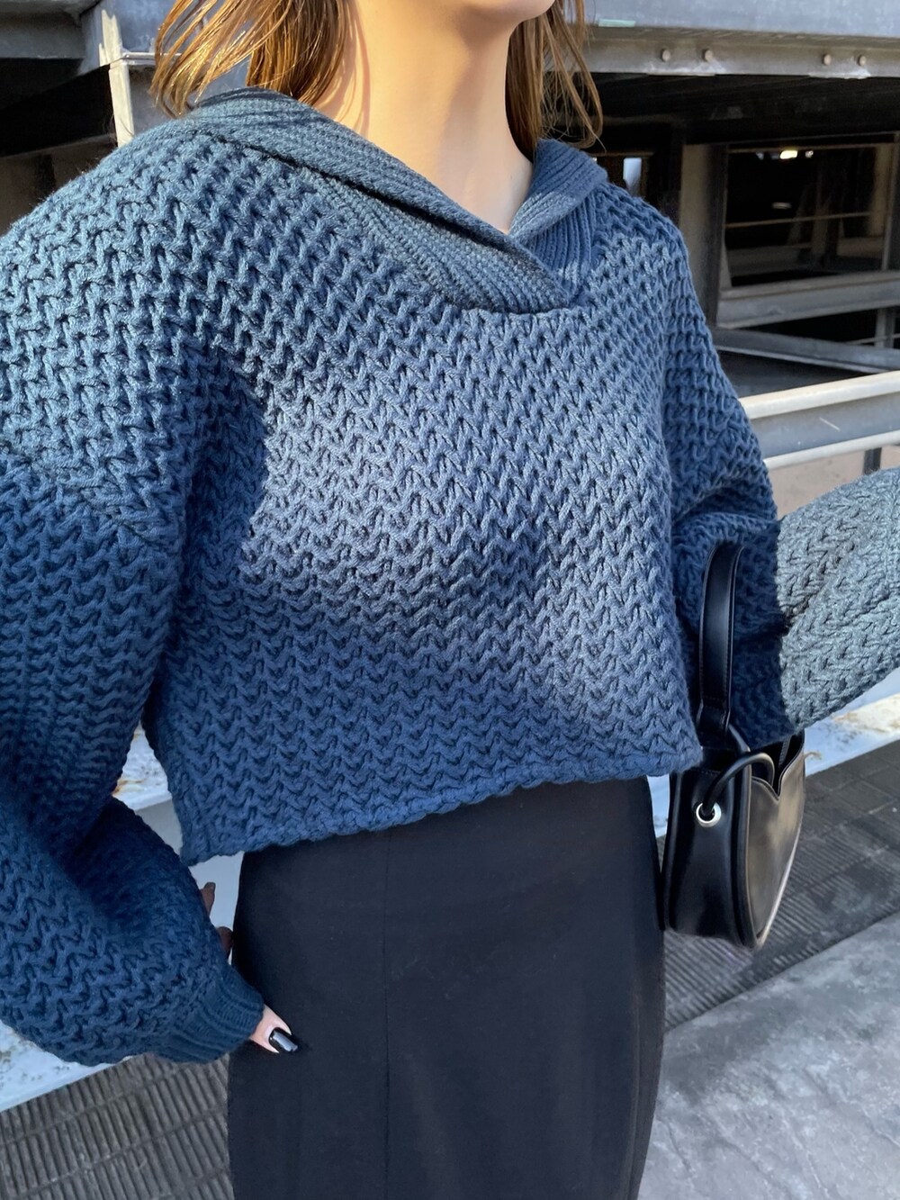 ブルー系のニット/セーター、ブラック系のハンドバッグ、ブラック系のスカートを着用したレディースの冬コーディネートの5枚目の写真