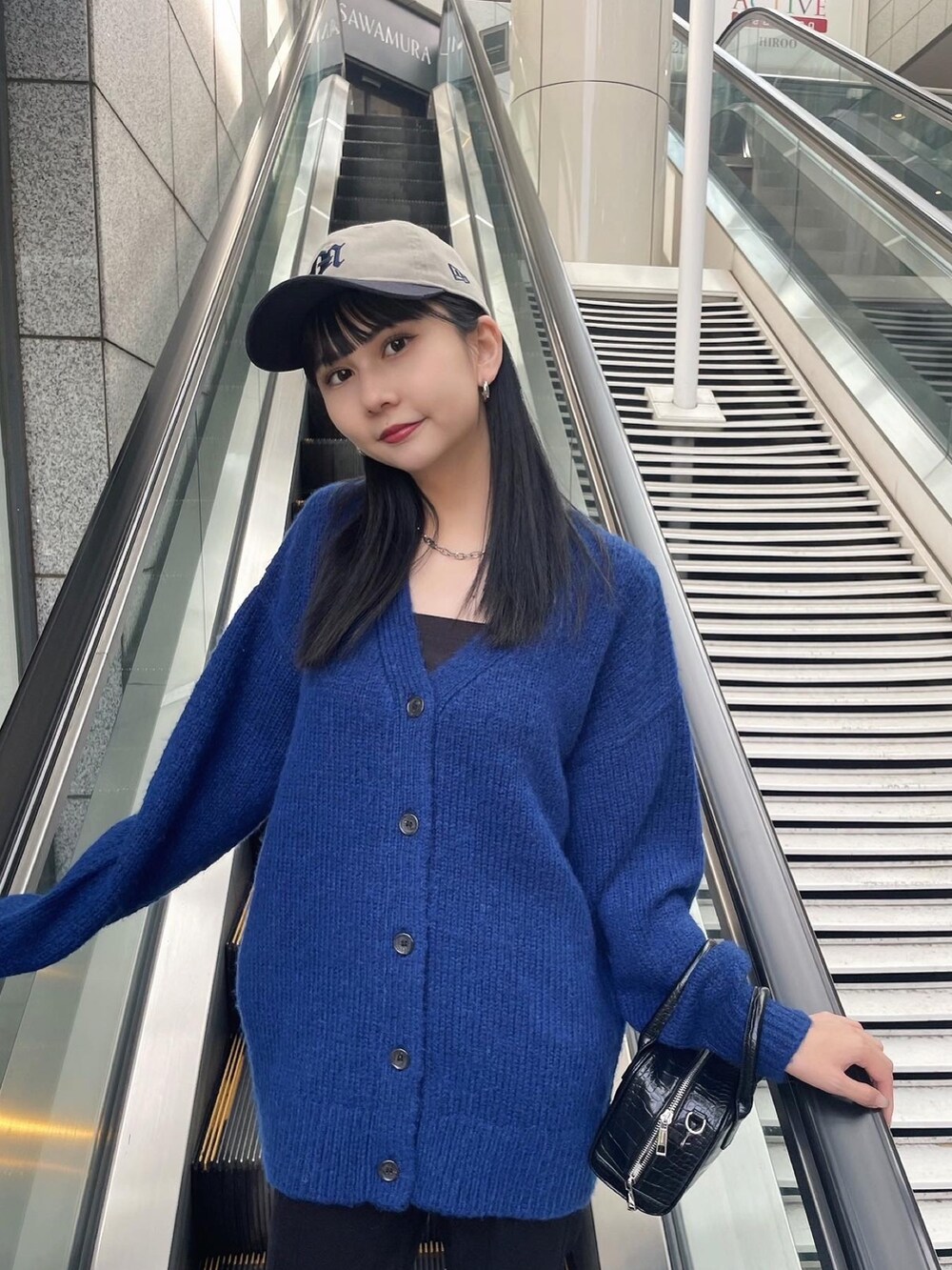 ブルー系のカーディガン/ボレロ、ブラック系のブーツ、ブラック系のその他パンツを着用したレディースの秋コーディネートの4枚目の写真