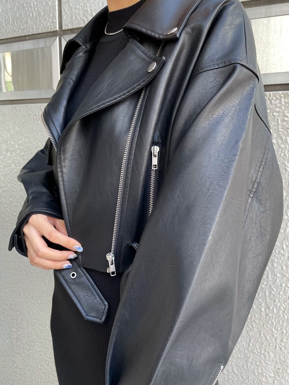 ブラック系のワンピース、ブラック系のライダースジャケット、ブラウン系のブーツを着用したレディースの秋コーディネートの5枚目の写真