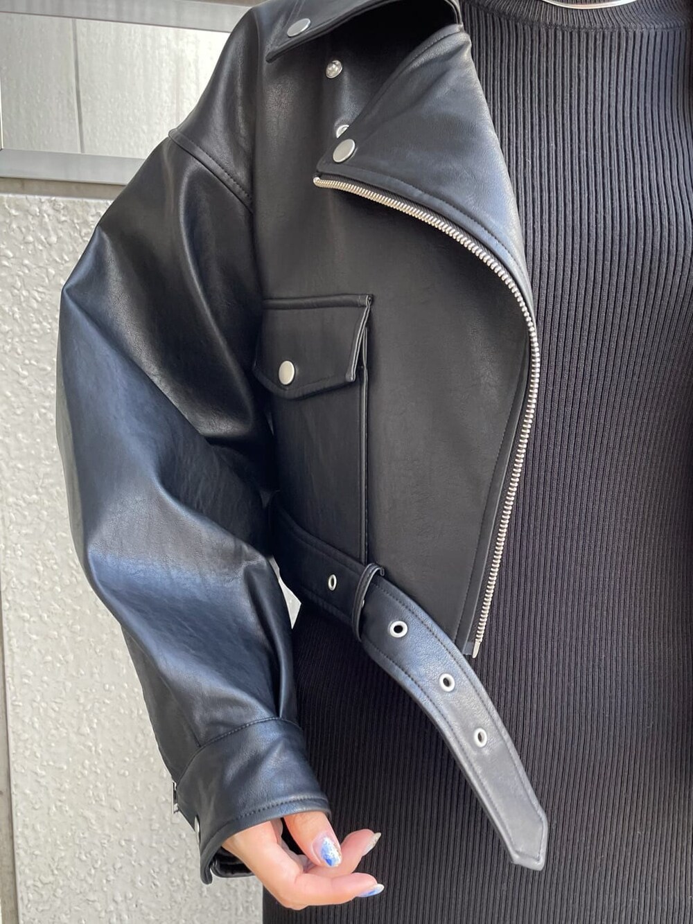 ブラック系のワンピース、ブラック系のライダースジャケット、ブラウン系のブーツを着用したレディースの秋コーディネートの6枚目の写真