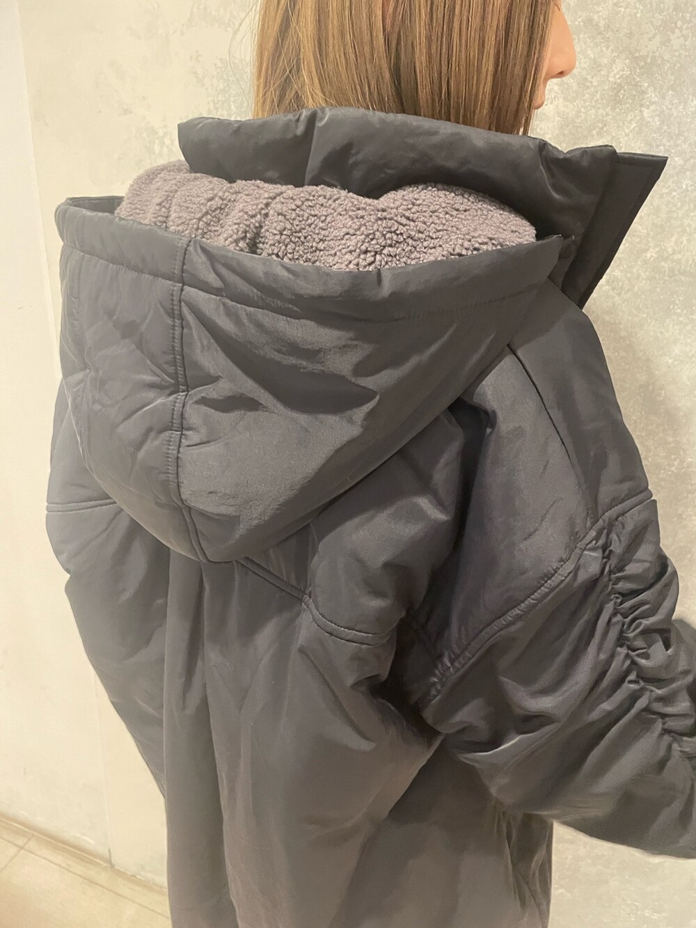 レッド系のニット/セーター、ブラック系のブルゾン、グレー系のスラックスを着用したレディースの冬コーディネートの9枚目の写真