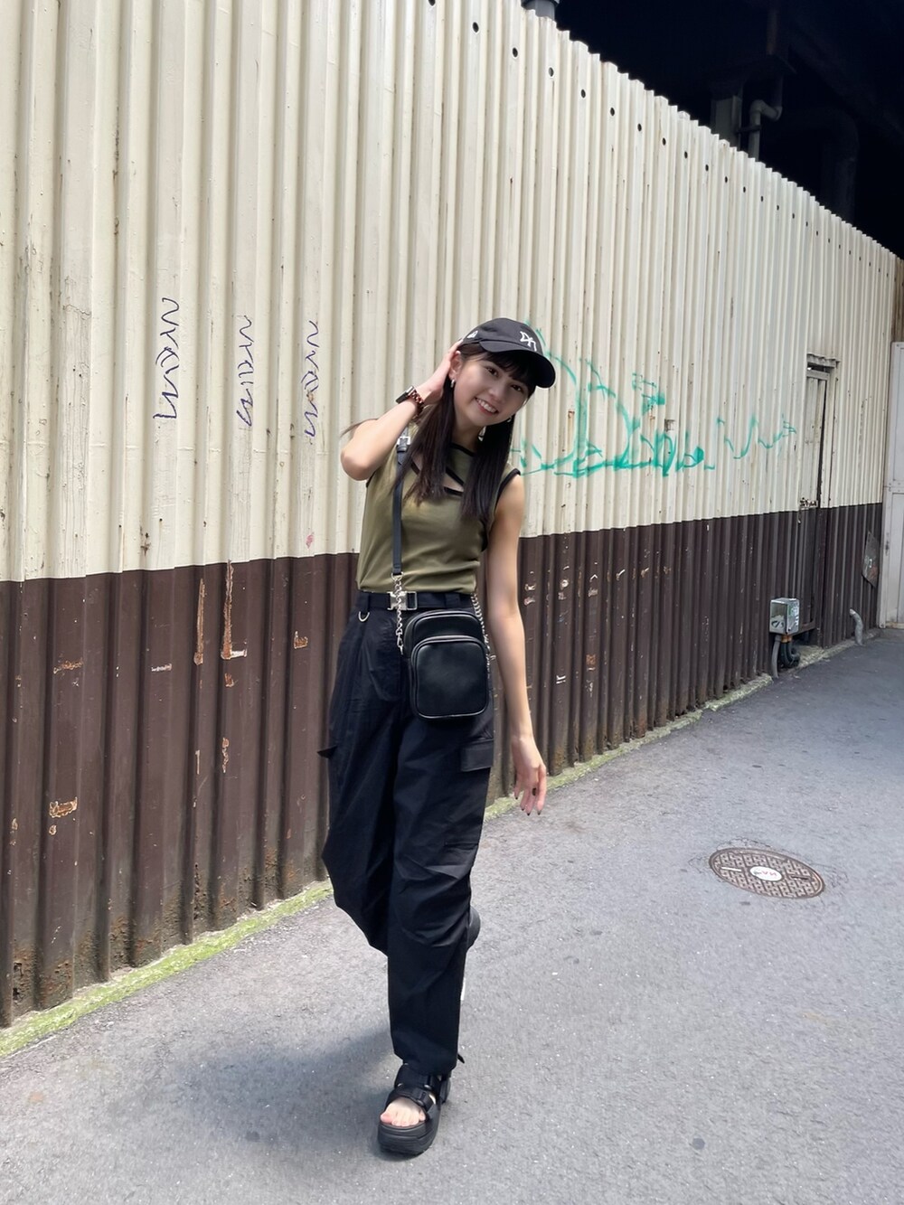 ベージュ系のタンクトップ、ブラック系のカーゴパンツ、ブラック系のサンダルを着用したレディースの夏コーディネートの4枚目の写真