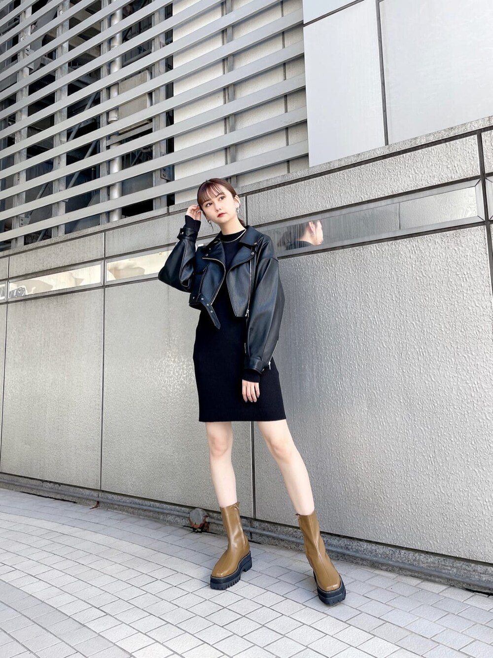 ブラック系のワンピース、ブラック系のライダースジャケット、ブラウン系のブーツを着用したレディースの秋コーディネートの2枚目の写真