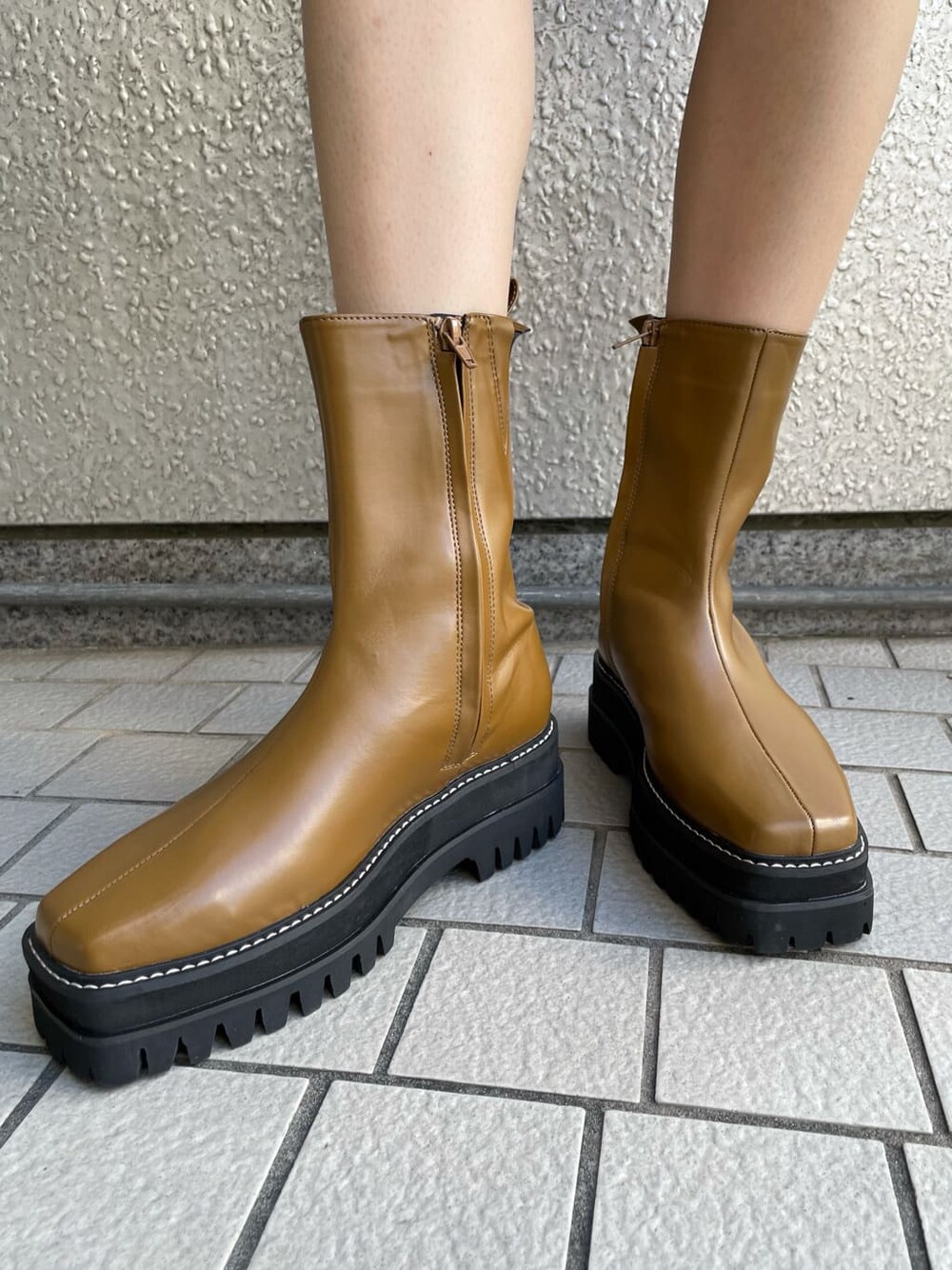 ブラック系のワンピース、ブラック系のライダースジャケット、ブラウン系のブーツを着用したレディースの秋コーディネートの8枚目の写真