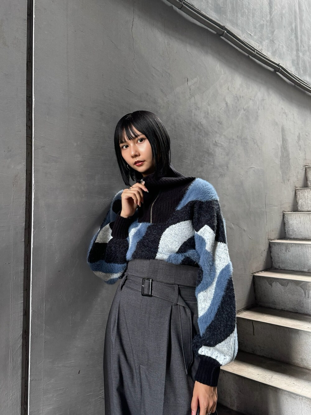 ブルー系のニット/セーター、グレー系のその他パンツ、ブラック系のブーツを着用したレディースの秋コーディネートの3枚目の写真