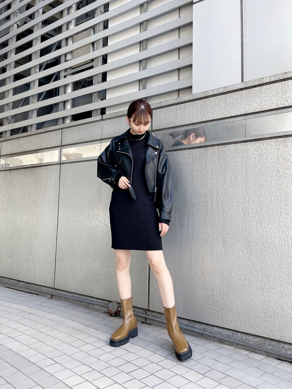 ブラック系のワンピース、ブラック系のライダースジャケット、ブラウン系のブーツを着用したレディースの秋コーディネートの3枚目の写真