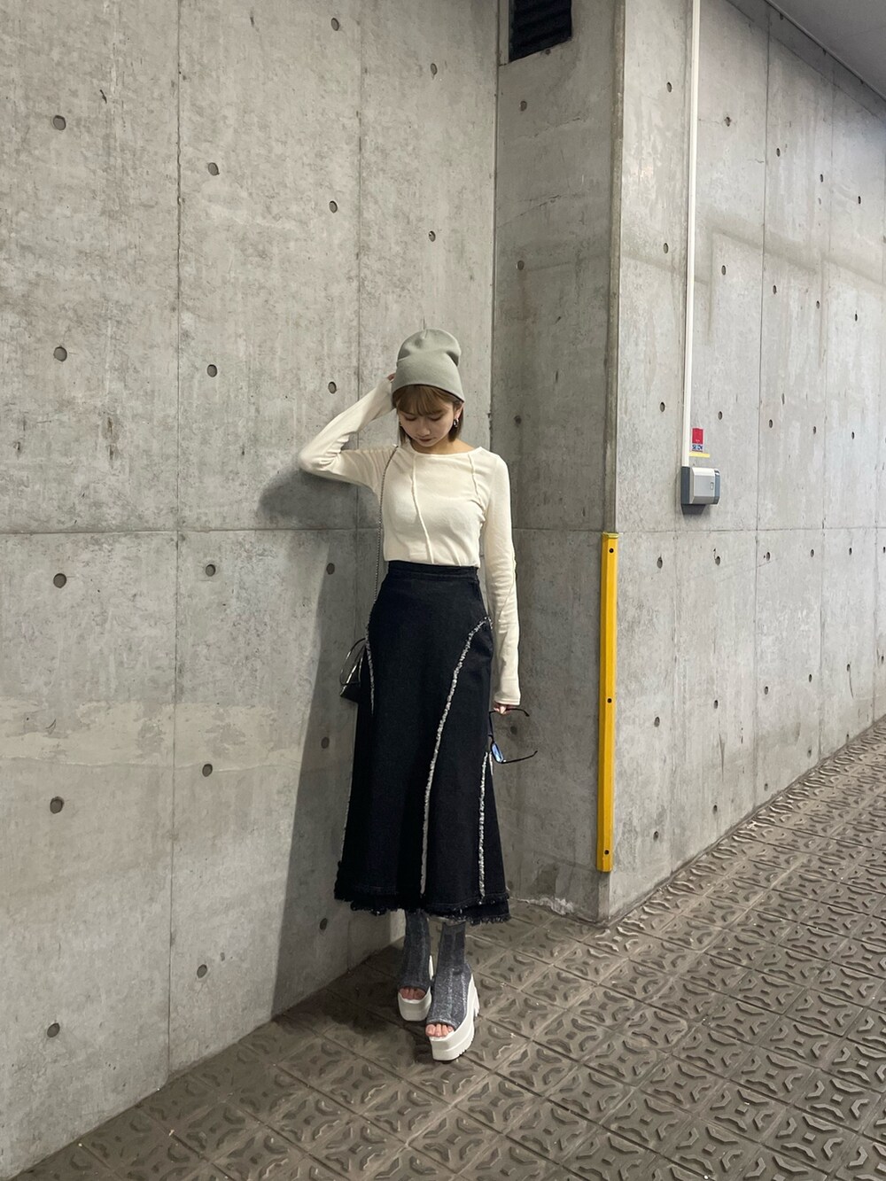 ホワイト系のTシャツ/カットソー、ホワイト系のTシャツ/カットソー、ブラック系のデニムスカートを着用したレディースの冬コーディネートの2枚目の写真