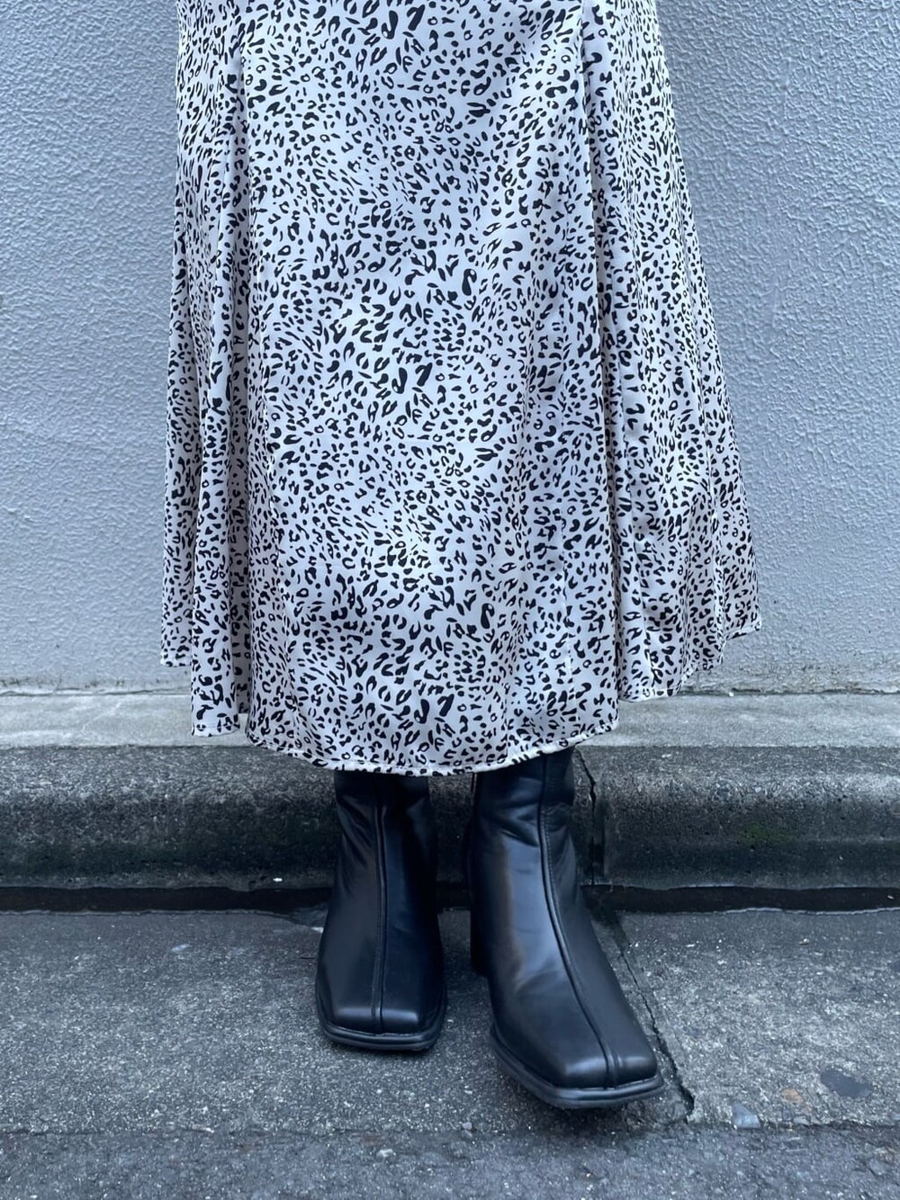 ブラック系のブーツ、ブラック系のハンドバッグ、その他のスカートを着用したレディースの夏コーディネートの4枚目の写真