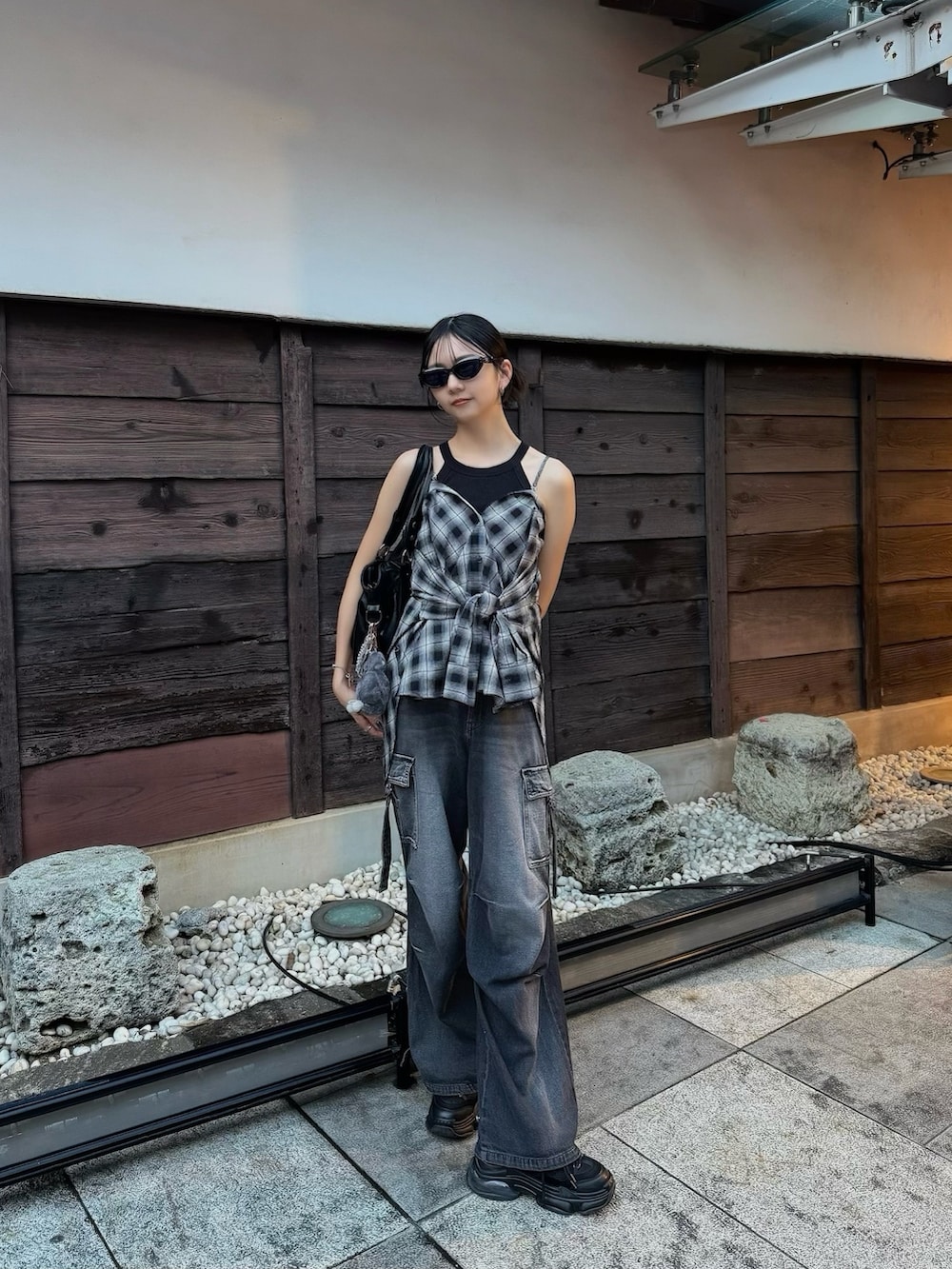 ブラック系のデニムパンツ、ブラック系のシャツ/ブラウスを着用したレディースの夏コーディネートの2枚目の写真