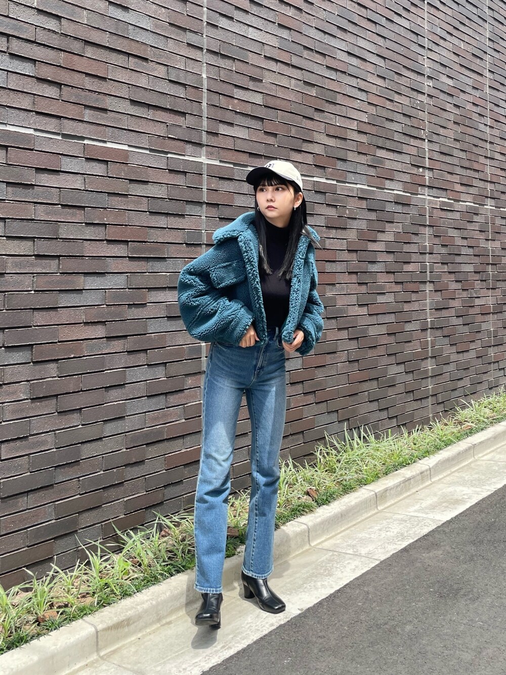 ブルー系のデニムパンツ、ブラック系のブーツ、ブルー系のブルゾンを着用したレディースの秋コーディネートの2枚目の写真