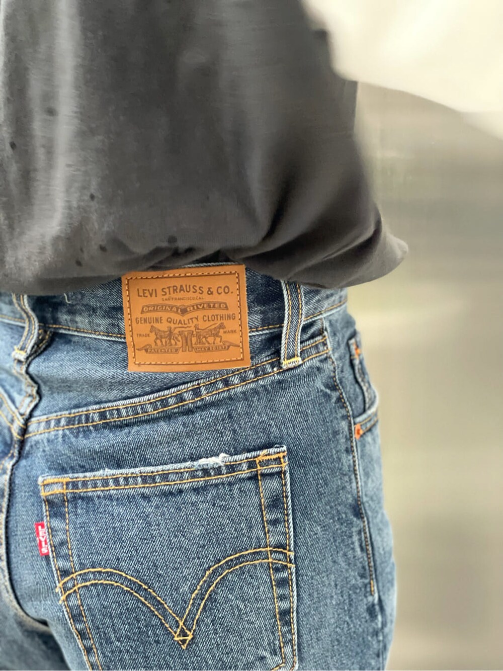 ブルー系のデニムパンツ、グレー系のTシャツ/カットソーを着用したレディースの夏コーディネートの3枚目の写真