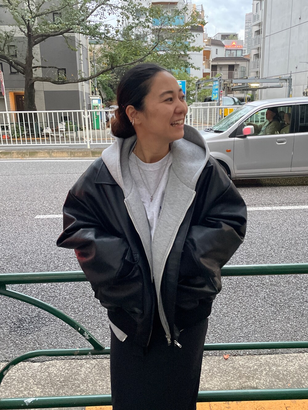 ブラック系のブルゾン、グレー系のパーカーを着用したレディースの秋コーディネートの3枚目の写真