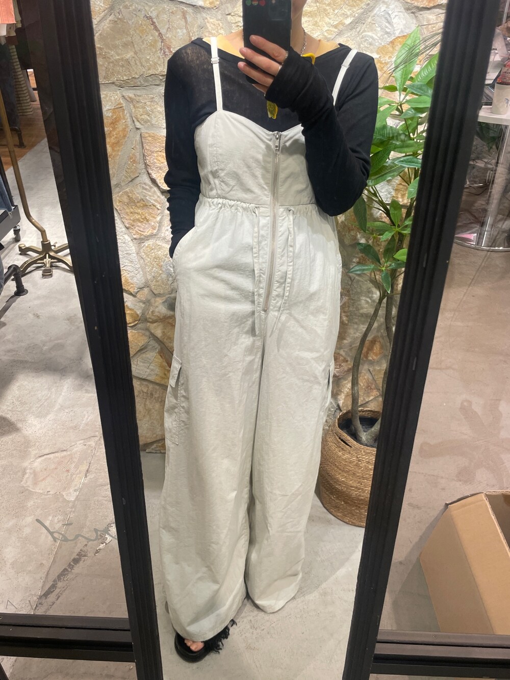 グレー系のサロペット/オーバーオール、ブラック系のTシャツ/カットソー、ブラック系のサンダルを着用したレディースの冬コーディネートの3枚目の写真