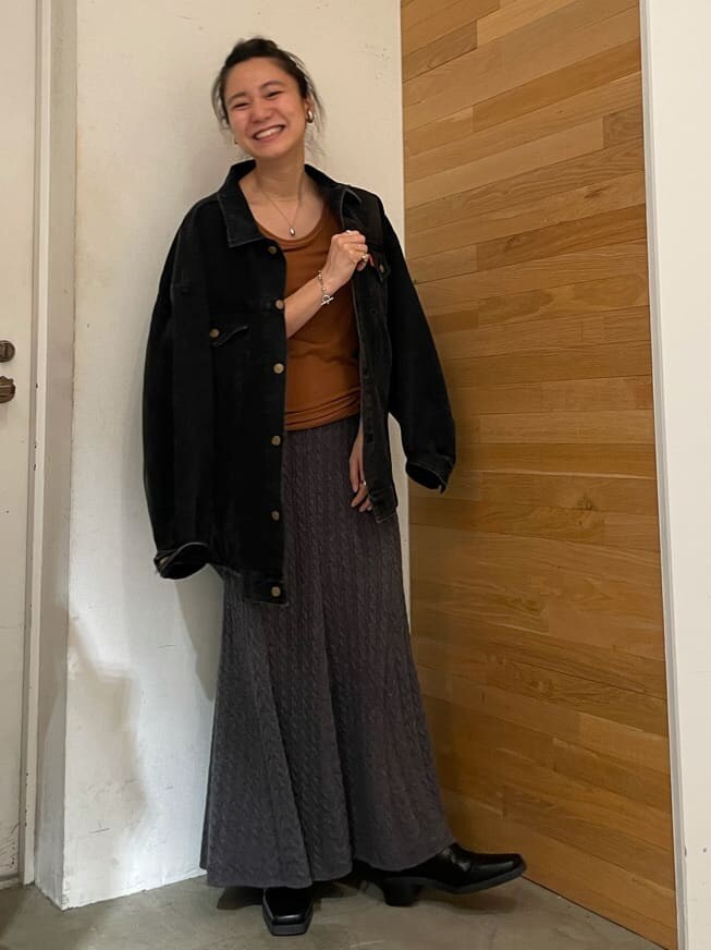 ブラウン系のタンクトップ、ブラック系のデニムジャケット、グレー系のスカートを着用したレディースの夏コーディネートの2枚目の写真