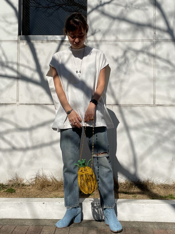 ブルー系のデニムパンツ、イエロー系のショルダーバッグ、ホワイト系のTシャツ/カットソーを着用したレディースの春コーディネートの2枚目の写真