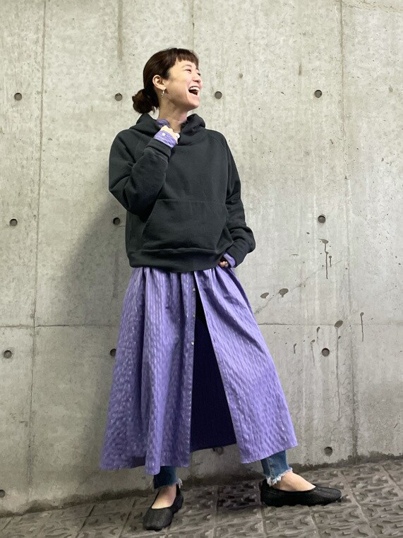 ブラック系のその他シューズ、ブルー系のデニムパンツ、パープル系のワンピースを着用したレディースの春コーディネートの2枚目の写真