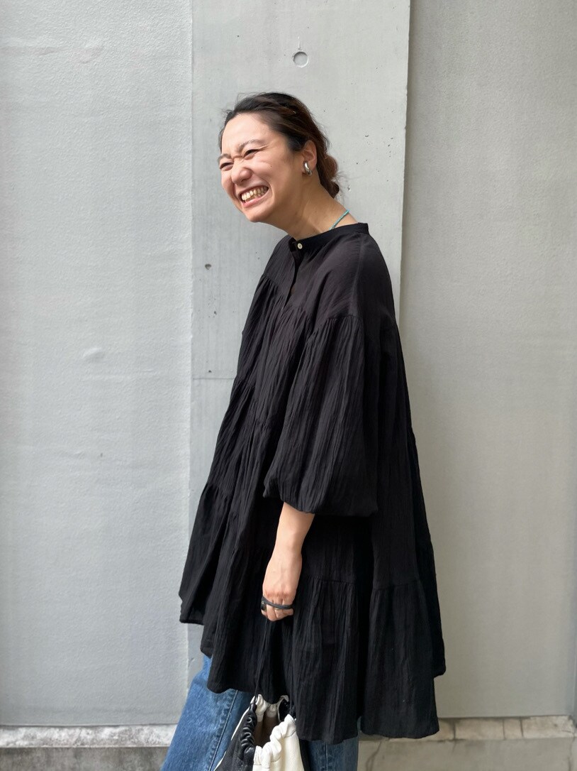 ブルー系のデニムパンツ、ブラック系のサンダル、ブラック系のワンピースを着用したレディースの春コーディネートの3枚目の写真