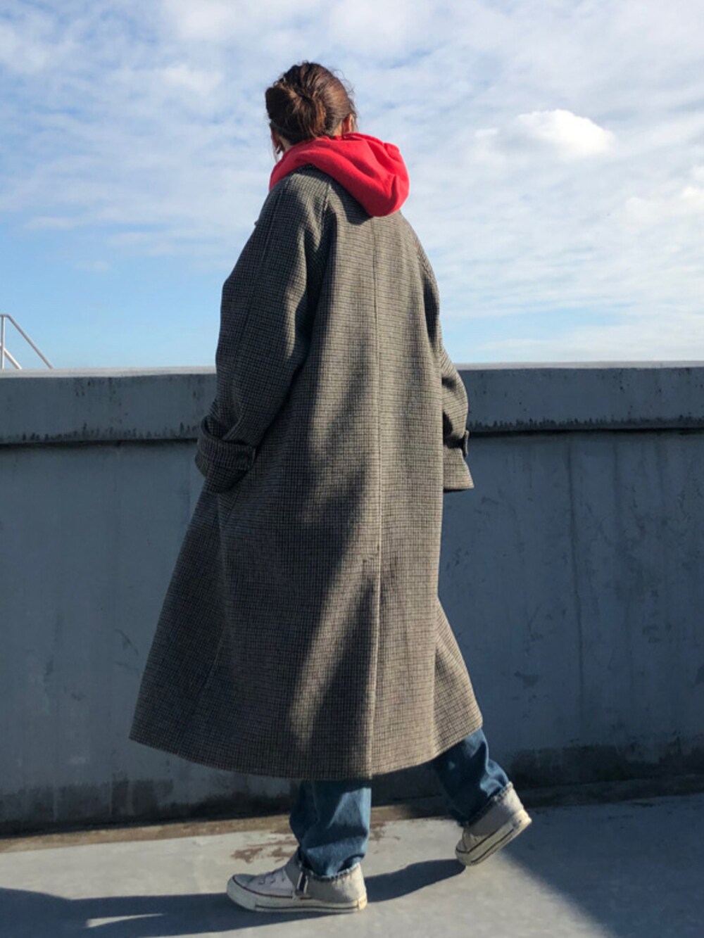 ブルー系のデニムパンツ、レッド系のパーカーを着用したレディースの秋コーディネートの2枚目の写真