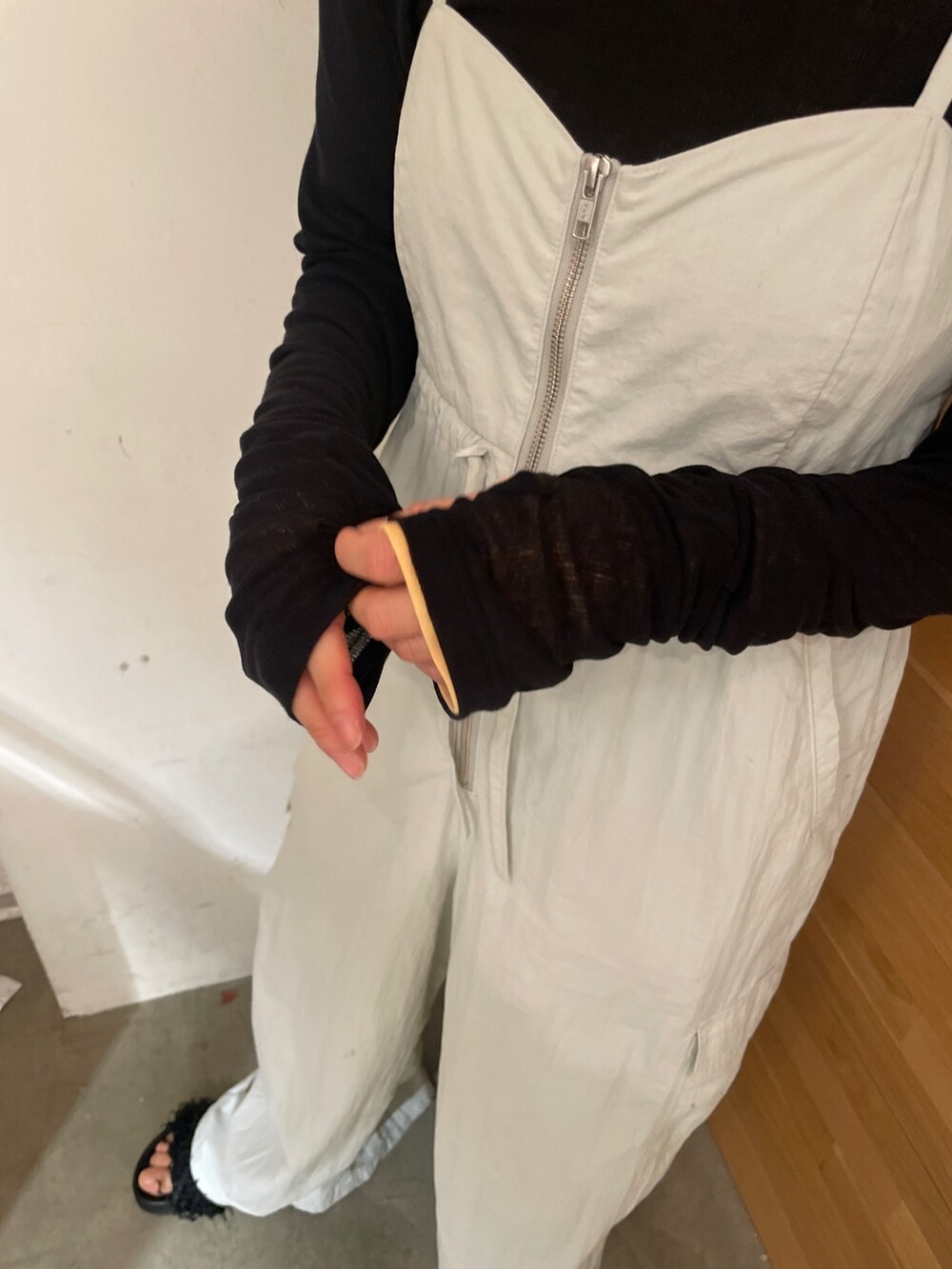 グレー系のサロペット/オーバーオール、ブラック系のTシャツ/カットソー、ブラック系のサンダルを着用したレディースの冬コーディネートの2枚目の写真