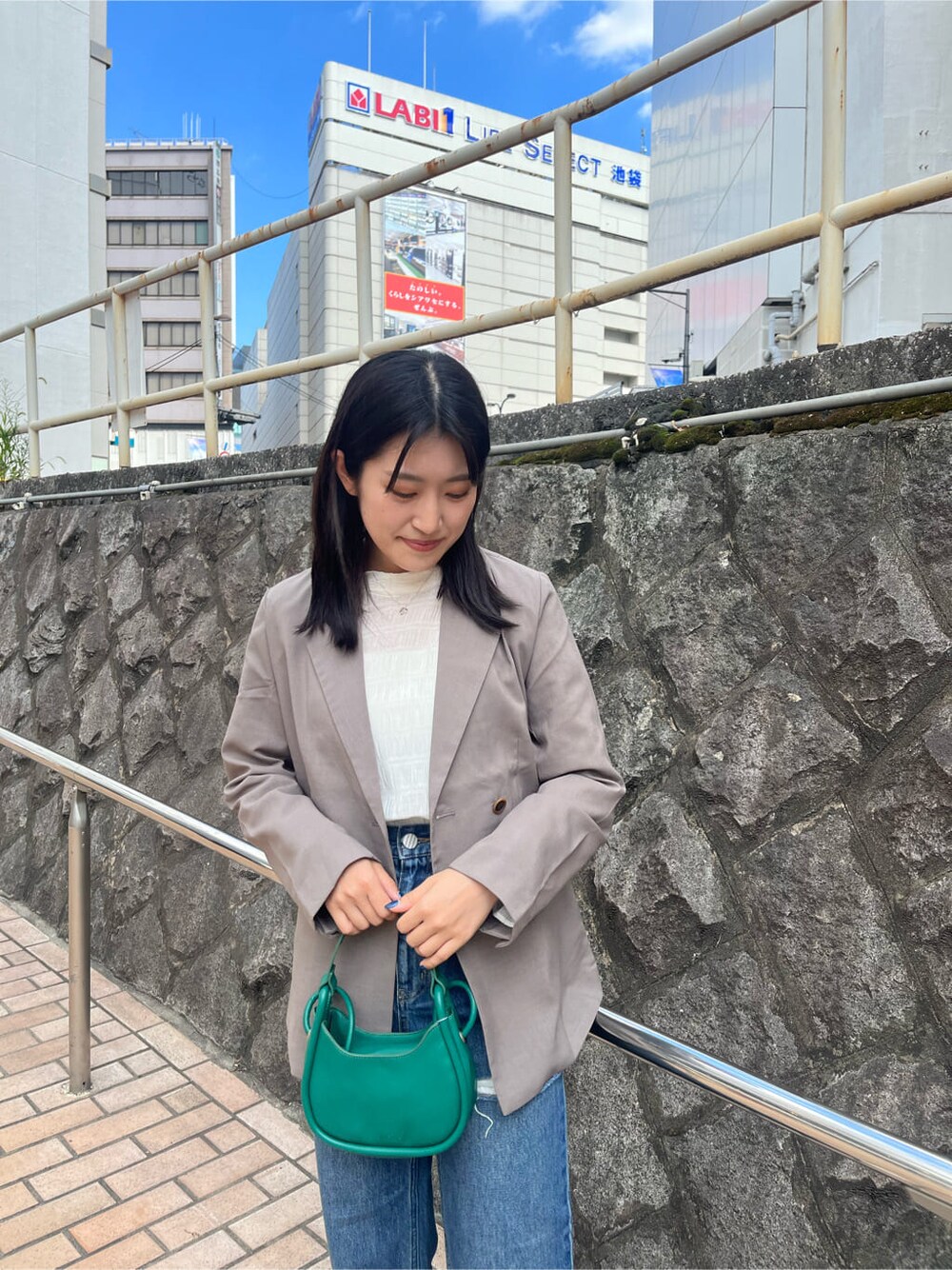 ホワイト系のシャツ/ブラウス、グレー系のテーラードジャケット、ブルー系のデニムパンツを着用したレディースの夏コーディネートの5枚目の写真