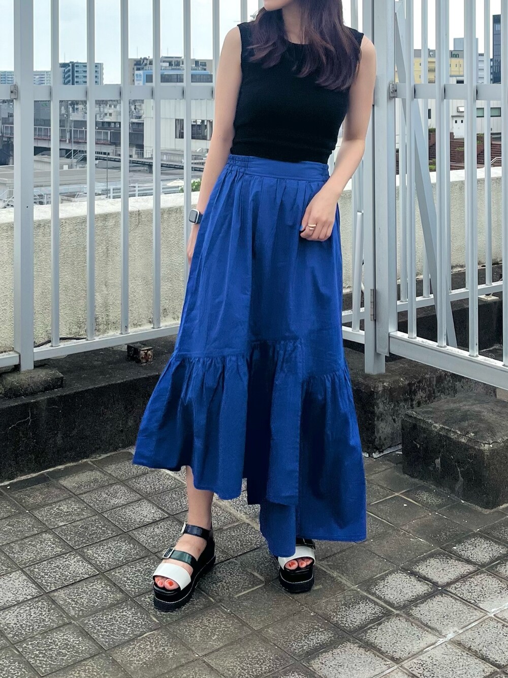 ブラック系のタンクトップ、ブルー系のスカートを着用したレディースの夏コーディネートの4枚目の写真