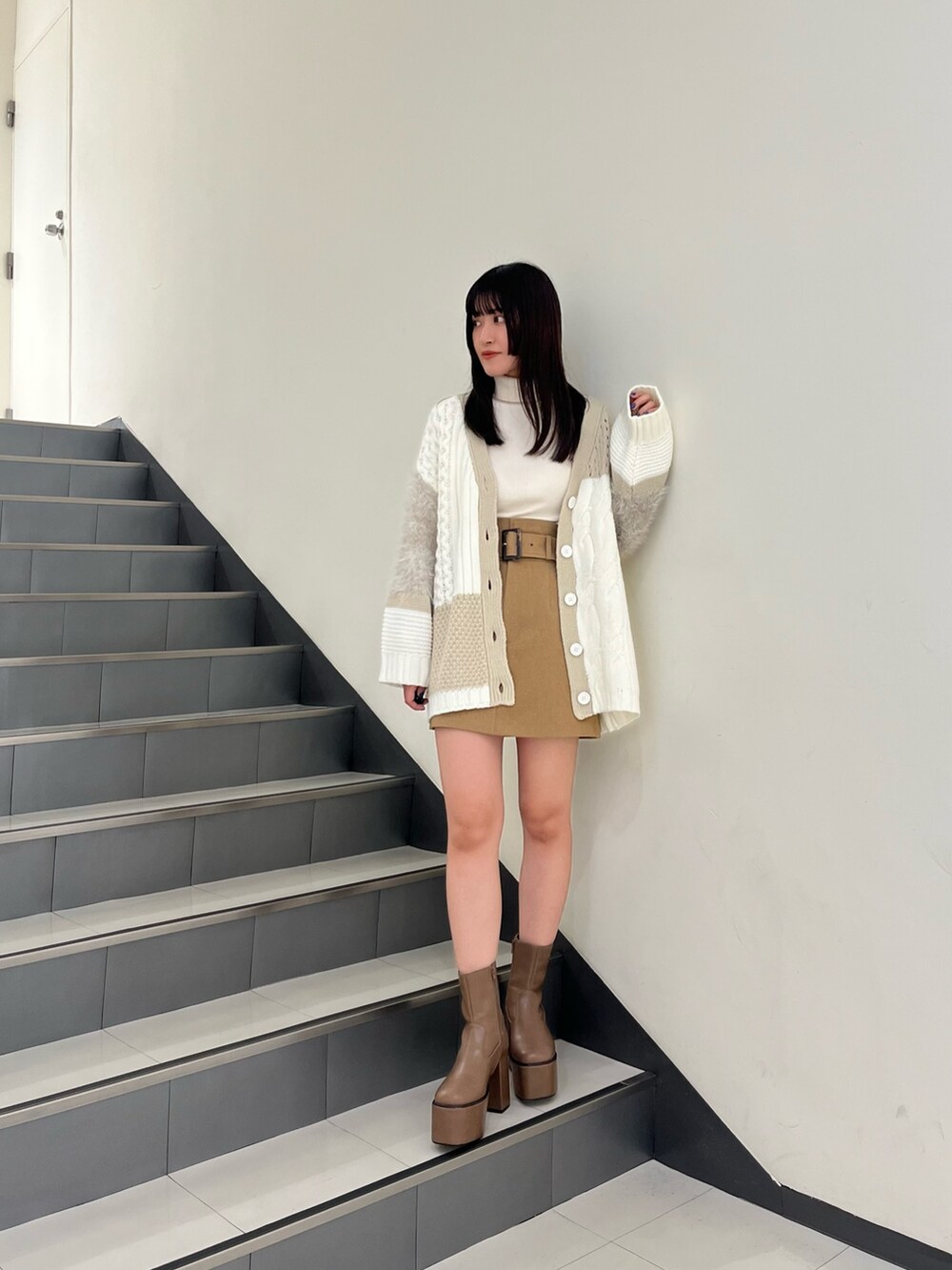 ホワイト系のカーディガン/ボレロ、ホワイト系のニット/セーター、ベージュ系のスカートを着用したレディースの秋コーディネートの2枚目の写真