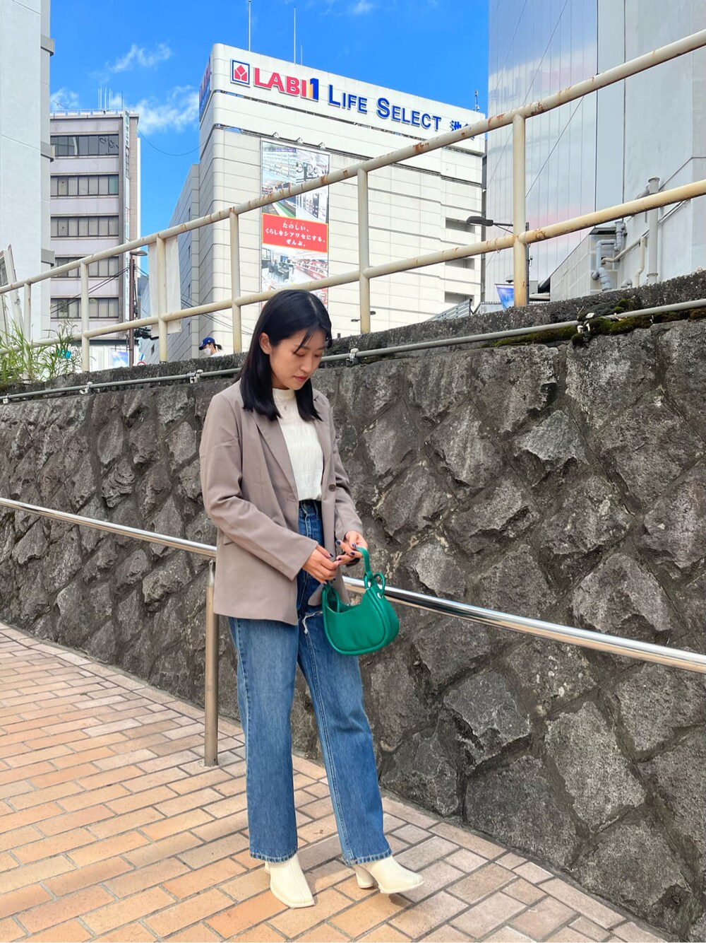 ホワイト系のシャツ/ブラウス、グレー系のテーラードジャケット、ブルー系のデニムパンツを着用したレディースの夏コーディネートの2枚目の写真