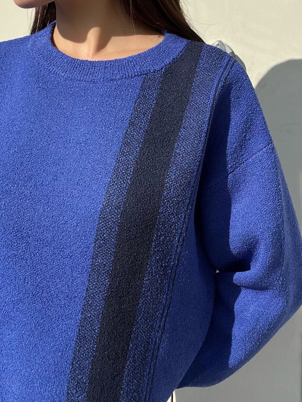 ブルー系のニット/セーター、ブルー系のスカート、ホワイト系のブーツを着用したレディースの冬コーディネートの5枚目の写真