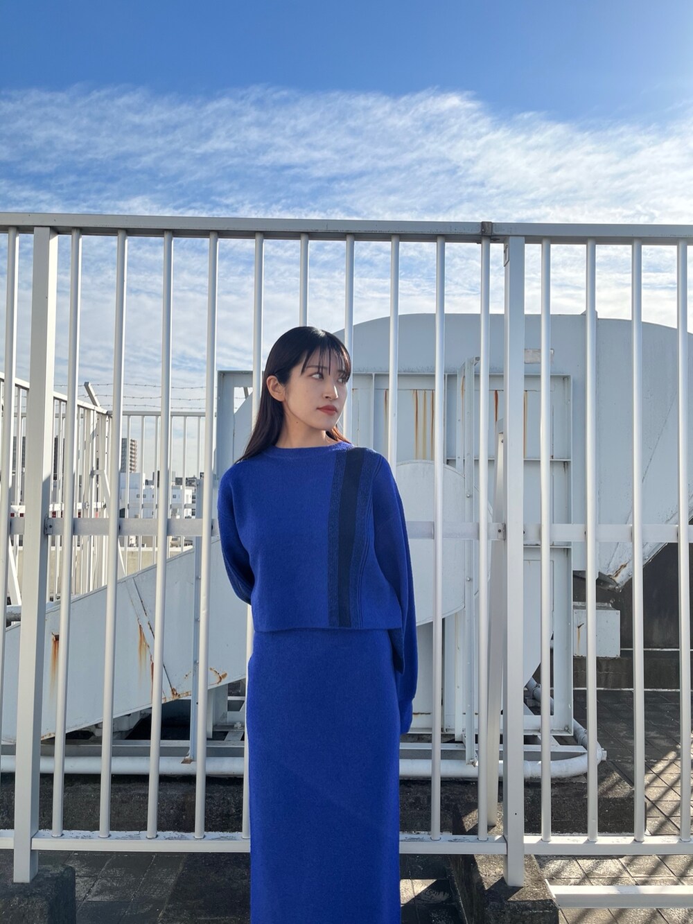 ブルー系のニット/セーター、ブルー系のスカート、ホワイト系のブーツを着用したレディースの冬コーディネートの4枚目の写真