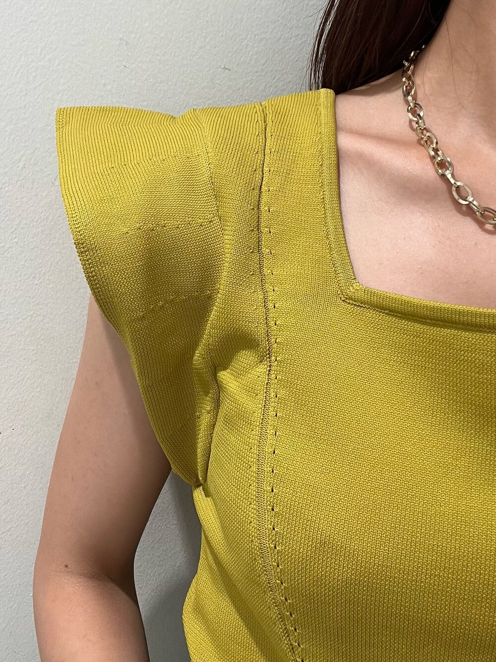 イエロー系のニット/セーター、ブラック系のデニムパンツを着用したレディースの夏コーディネートの4枚目の写真