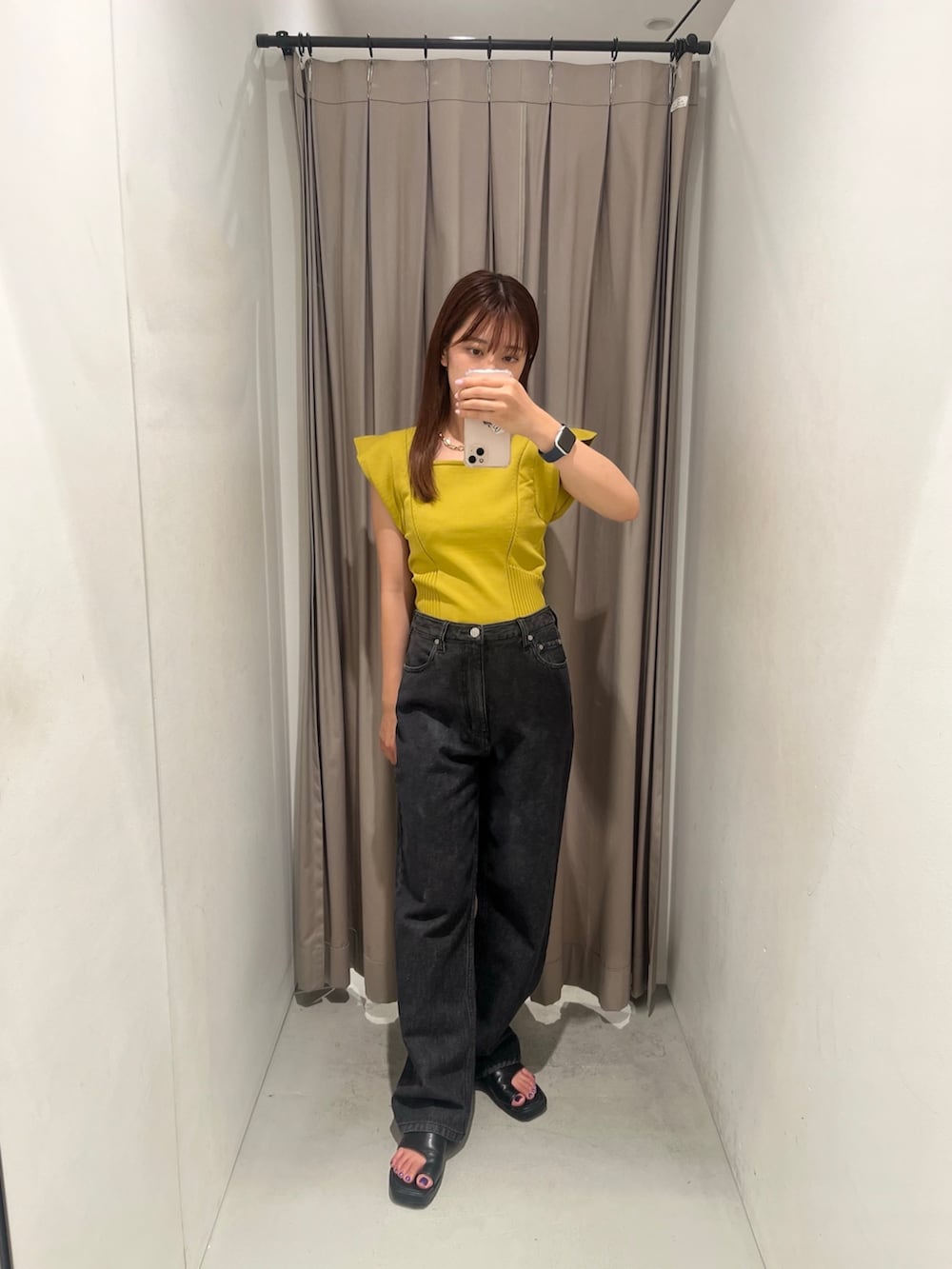イエロー系のニット/セーター、ブラック系のデニムパンツを着用したレディースの夏コーディネートの2枚目の写真