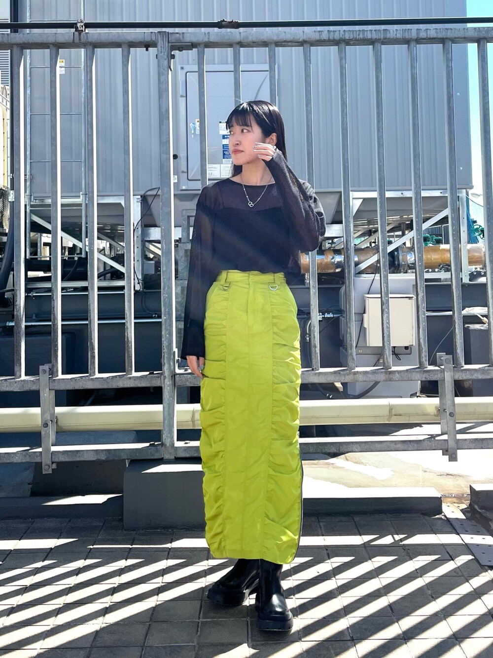 ブラック系のTシャツ/カットソー、グリーン系のスカート、ブラック系のブーツを着用したレディースの春コーディネートの3枚目の写真