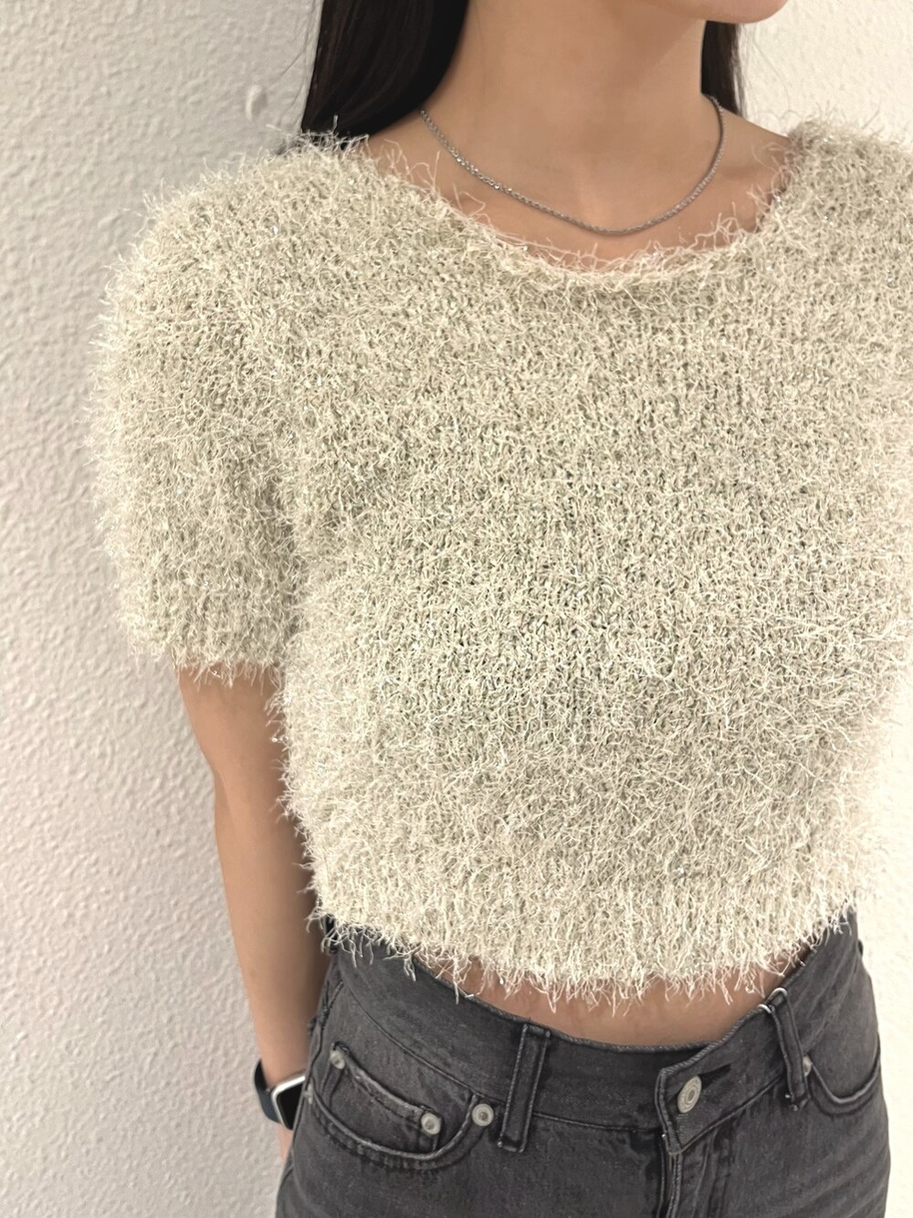 ホワイト系のニット/セーター、ブラック系のデニムパンツ、ホワイト系のハンドバッグを着用したレディースの春コーディネートの8枚目の写真