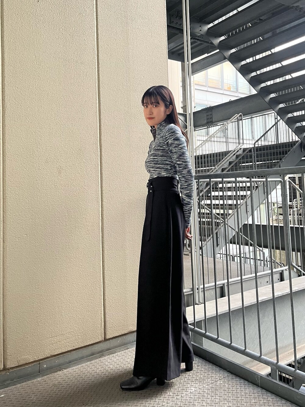 ブルー系のニット/セーター、ブラック系のその他パンツを着用したレディースの秋コーディネートの2枚目の写真