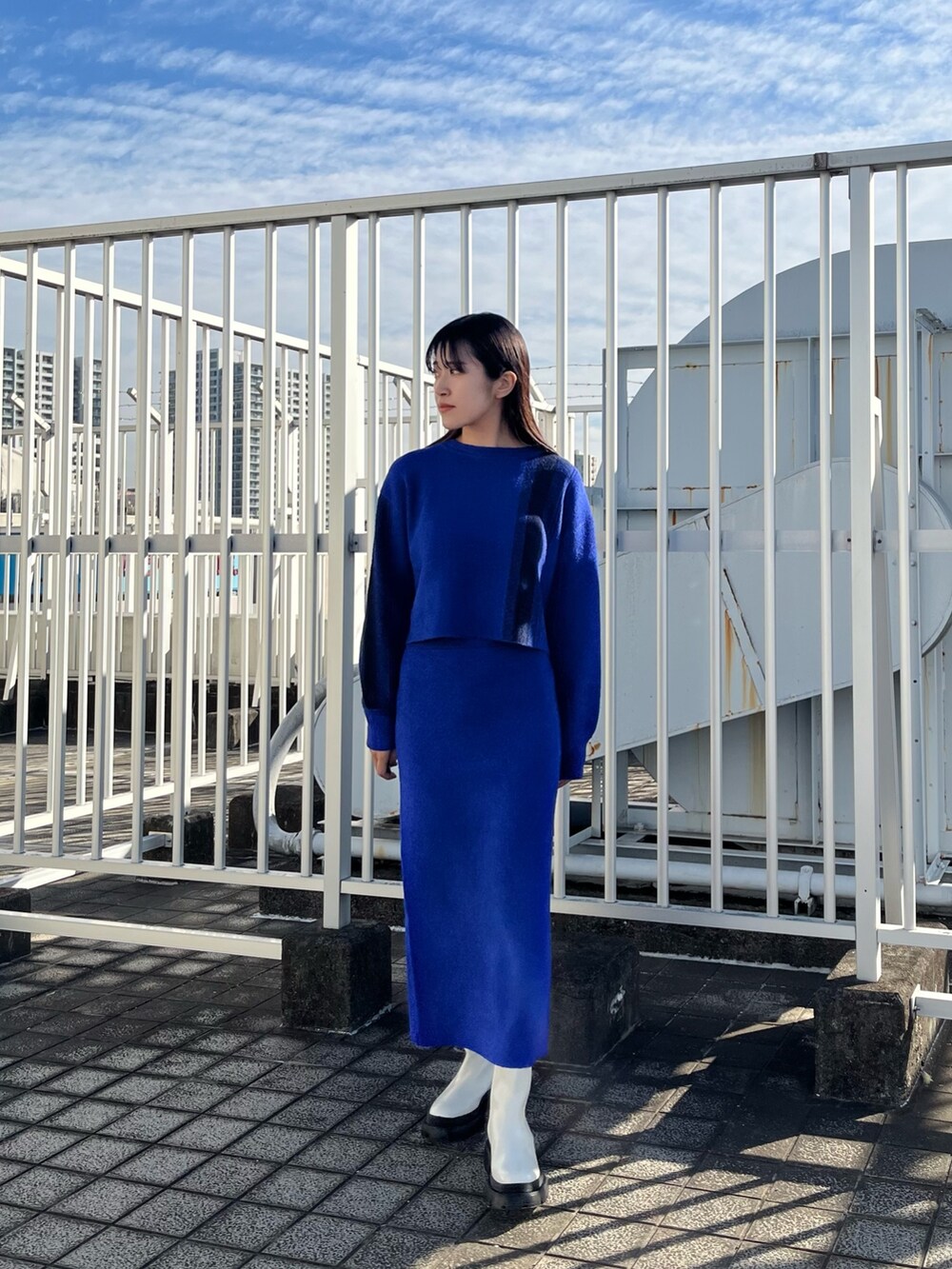 ブルー系のニット/セーター、ブルー系のスカート、ホワイト系のブーツを着用したレディースの冬コーディネートの3枚目の写真