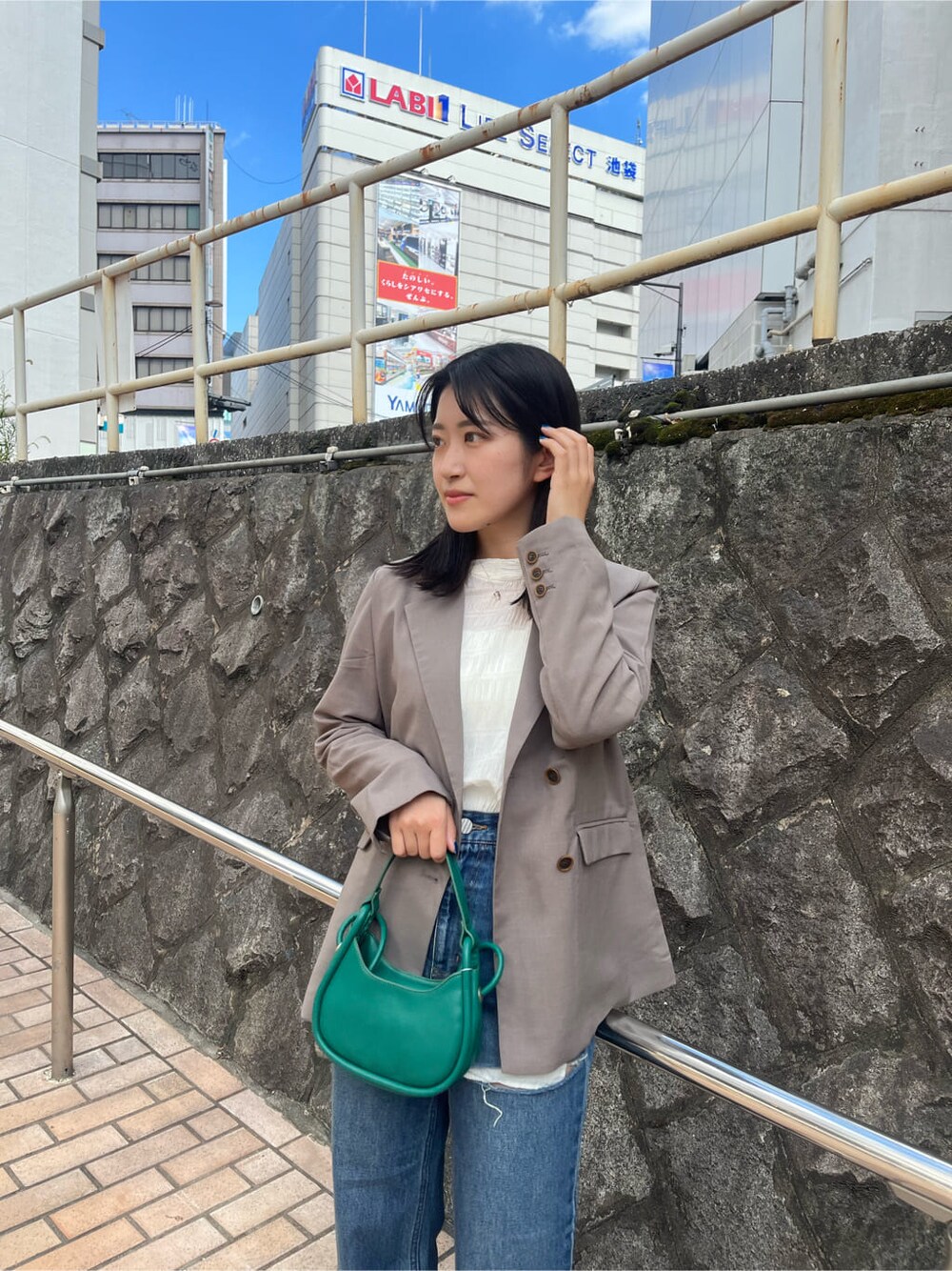 ホワイト系のシャツ/ブラウス、グレー系のテーラードジャケット、ブルー系のデニムパンツを着用したレディースの夏コーディネートの4枚目の写真