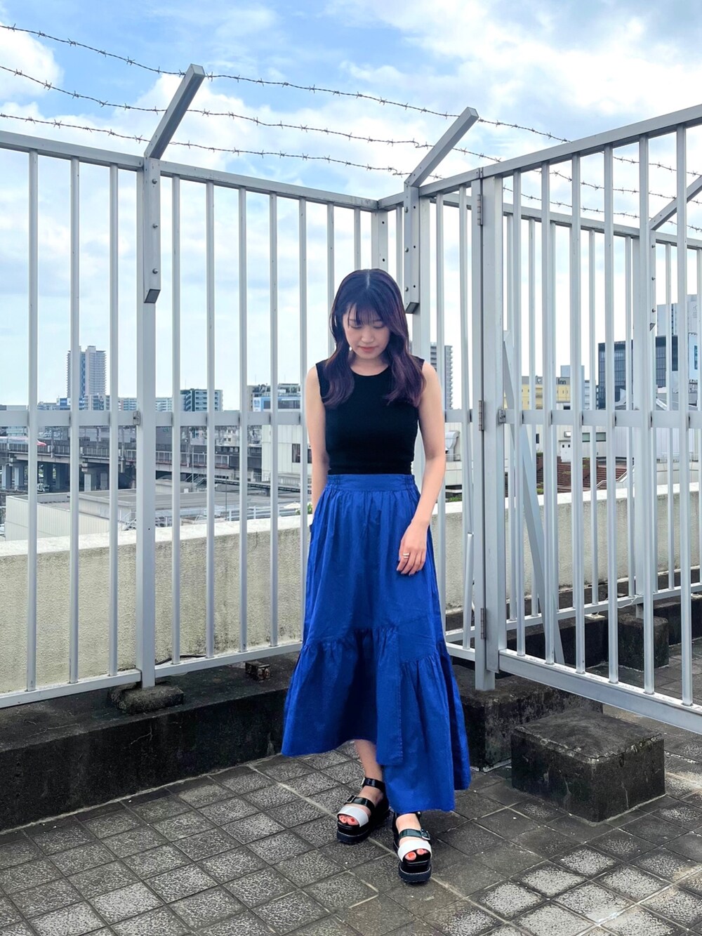 ブラック系のタンクトップ、ブルー系のスカートを着用したレディースの夏コーディネートの3枚目の写真