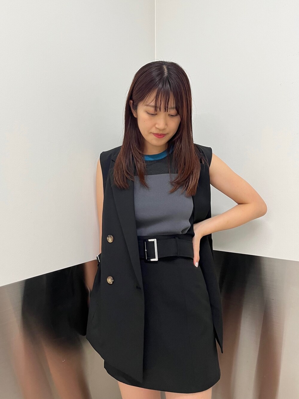 ブラック系のベスト、グレー系のニット/セーター、ブラック系のスカートを着用したレディースの夏コーディネートの4枚目の写真