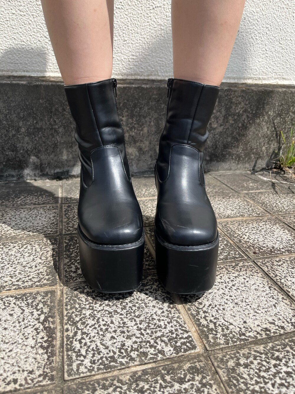 グレー系のテーラードジャケット、グレー系のスカート、ブラック系のブーツを着用したレディースの秋コーディネートの6枚目の写真