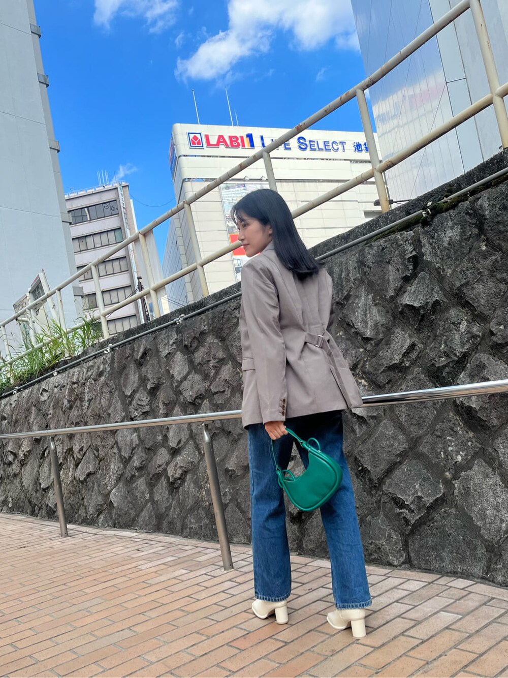 ホワイト系のシャツ/ブラウス、グレー系のテーラードジャケット、ブルー系のデニムパンツを着用したレディースの夏コーディネートの3枚目の写真