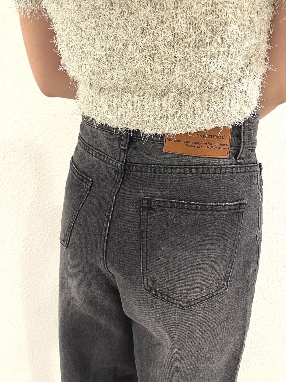 ホワイト系のニット/セーター、ブラック系のデニムパンツ、ホワイト系のハンドバッグを着用したレディースの春コーディネートの7枚目の写真