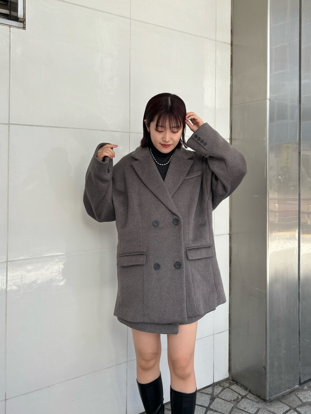 ブラック系のニット/セーター、ブラウン系のテーラードジャケット、ブラウン系のスカートを着用したレディースの秋コーディネートの5枚目の写真