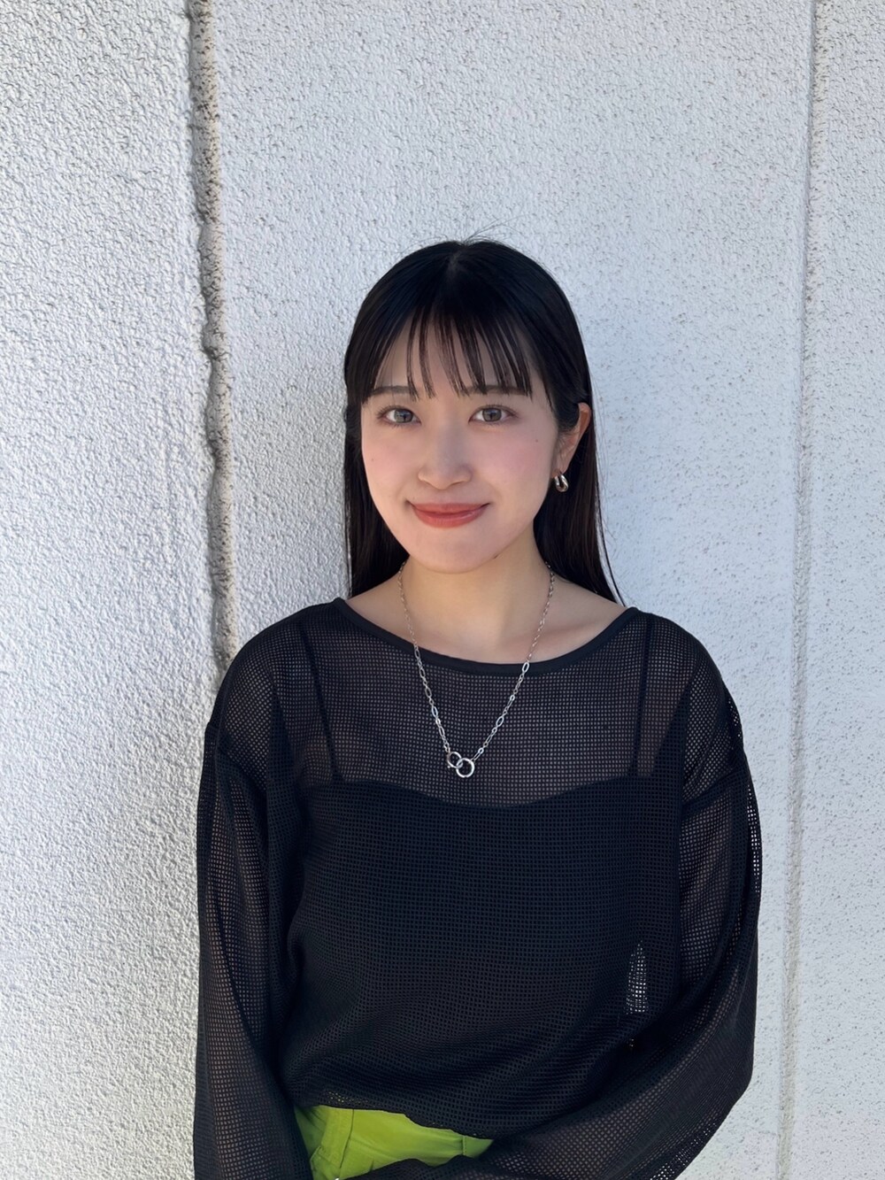 ブラック系のTシャツ/カットソー、グリーン系のスカート、ブラック系のブーツを着用したレディースの春コーディネートの6枚目の写真