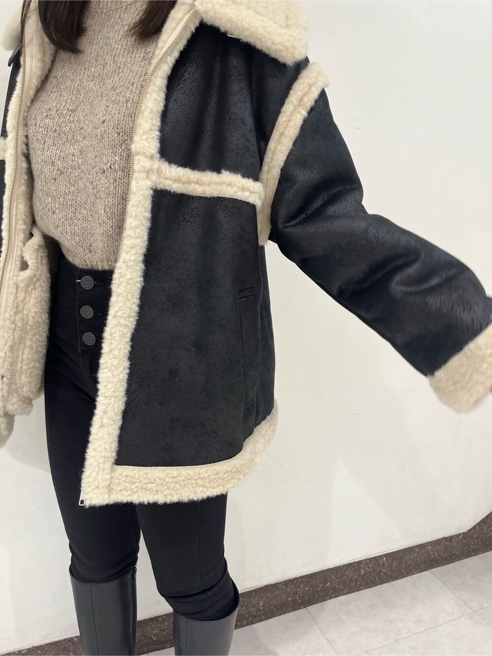 ブラック系のブーツ、ブラック系のムートンコート、ブラック系のデニムパンツを着用したレディースの秋コーディネートの6枚目の写真