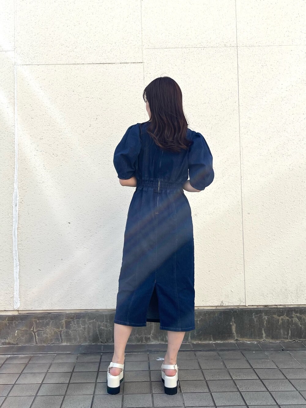 ブルー系のワンピース、シルバー系のハンドバッグ、ホワイト系のサンダルを着用したレディースの春コーディネートの3枚目の写真