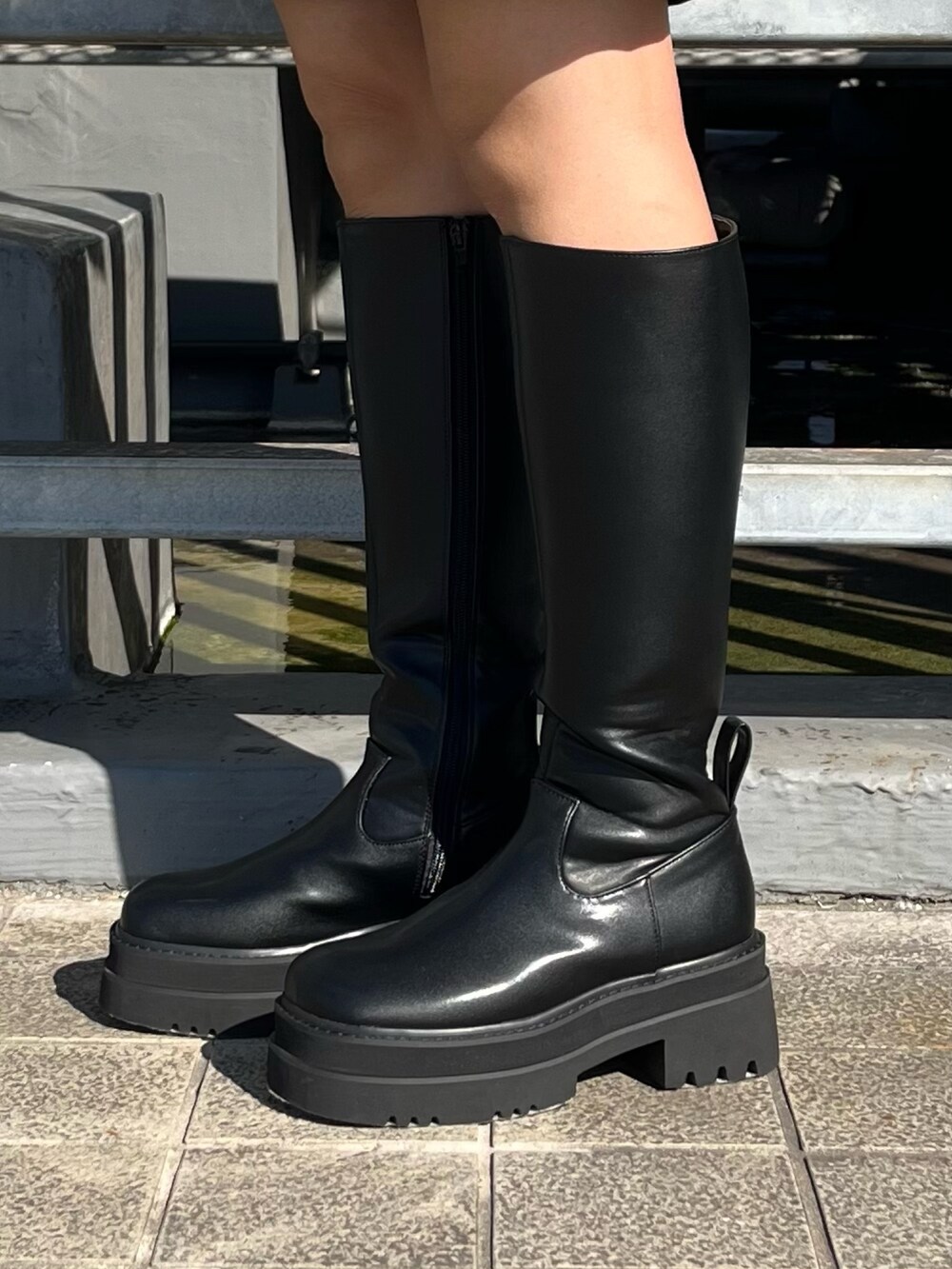 ブラック系のニット/セーター、ブラック系のその他パンツ、ブラック系のブーツを着用したレディースの秋コーディネートの8枚目の写真