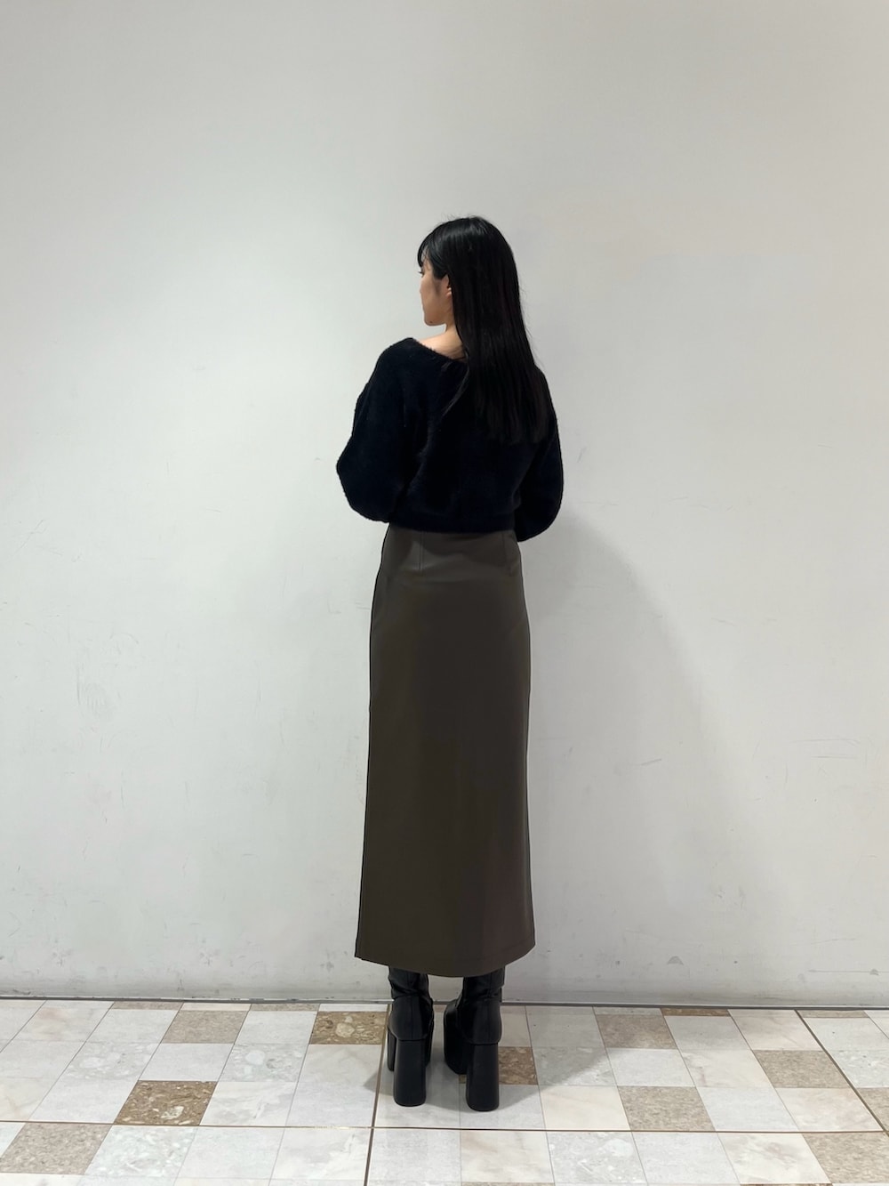 ブラウン系のスカート、ブラック系のニット/セーターを着用したレディースの秋コーディネートの3枚目の写真
