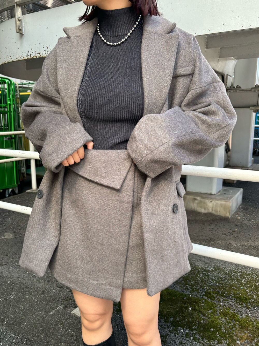 ブラック系のニット/セーター、ブラウン系のテーラードジャケット、ブラウン系のスカートを着用したレディースの秋コーディネートの6枚目の写真