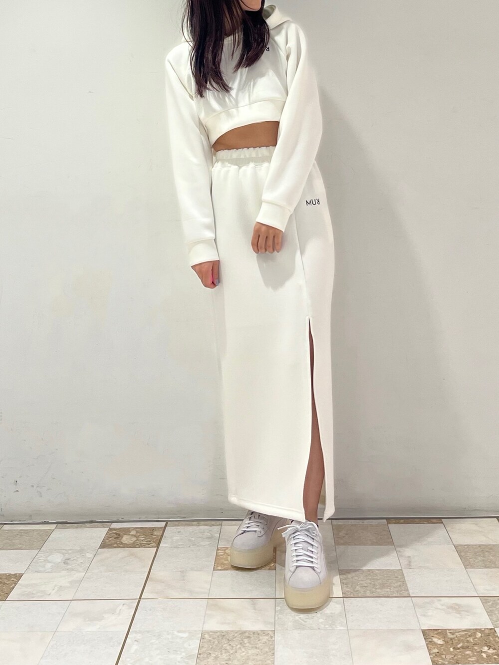 ホワイト系のTシャツ/カットソー、ホワイト系のスカート、グレー系のスニーカーを着用したレディースの春コーディネートの3枚目の写真